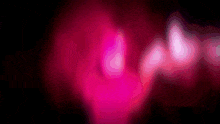 a blurry picture of a pink light coming out of a dark room .