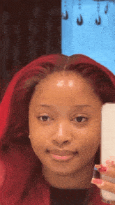 a woman with red hair is taking a picture of herself in a mirror
