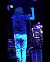 a man singing into a microphone on stage