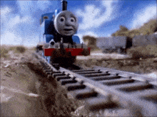 thomas the train is going down the tracks in a cartoon .
