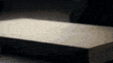 a piece of wood is sitting on a table in the dark