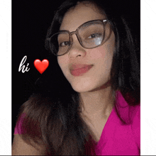 a woman wearing glasses and a pink shirt says hi with a red heart behind her
