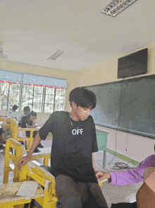 a boy wearing a black shirt that says off