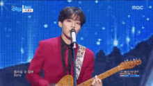 a group of people playing instruments on a stage with a sign that says mbc
