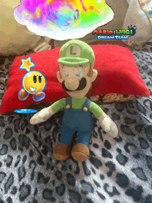 a mario luigi stuffed animal is sitting on a leopard print blanket