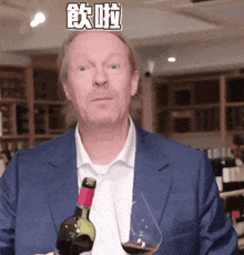 a man in a blue suit holds a bottle of wine and a glass