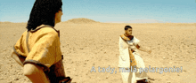 a man in a yellow shirt stands next to another man in a white robe in the desert with the words a tady mala pel argonie