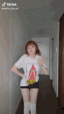 a girl is dancing in a hallway wearing a shirt that says ' scorpions ' on it