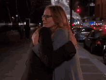 two women hugging each other on a street with the letters c on the bottom