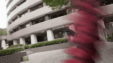 a person walking in front of a building with red smoke coming out of their mouth