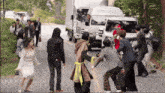 a group of people are standing on the side of a road in front of a truck that says tv asahi