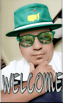 a man wearing a green hat and sunglasses with the word welcome written below him