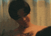 a man without a shirt is laying on a bed with candles in the background