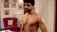 a shirtless man is standing in front of a mirror in a room .