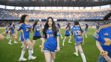 a group of girls are dancing on a soccer field wearing jerseys that say s28