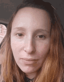 a close up of a woman 's face with a nose piercing