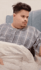 a man in a plaid shirt is laying in a bed