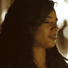 a close up of a woman 's face with a shadow behind her