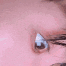 a close up of a woman 's face with a pink background