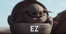 a baby yoda sits in a helmet with the words ez written on the bottom