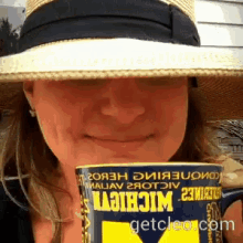 a woman wearing a hat is holding a can of michigan