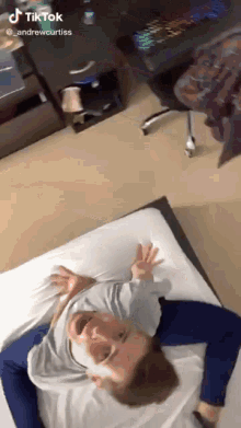 a man is laying on a bed with his legs crossed and a tiktok watermark on the bottom