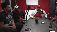 a group of men are sitting at a table with microphones .