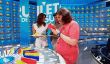 a man in a pink shirt is playing a game on a television show .
