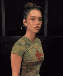 a woman in a green shirt with a cross on it is clapping her hands