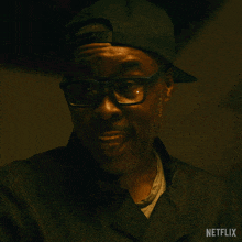 a man wearing glasses and a baseball cap says congratulations