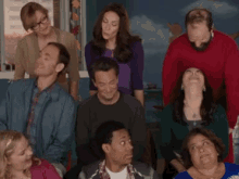 a group of people are posing for a picture and one of them is wearing glasses