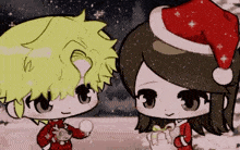 a boy and a girl are standing next to each other wearing santa hats .