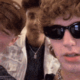 a group of young men wearing sunglasses and a necklace