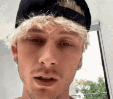a close up of a man 's face wearing a hat .