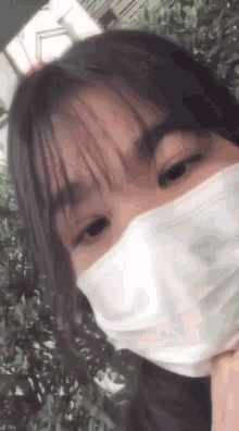 a close up of a girl wearing a white mask .