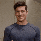 a man wearing a blue shirt with a letter a on it