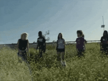 a group of people standing in a field with one wearing a shirt that says ' i love you ' on it