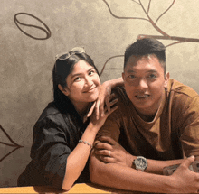 a man and a woman are posing for a picture and the man has a watch on