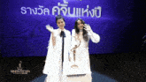 two women are standing next to a trophy that says nineentertainment awards