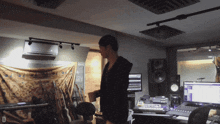 a man in a recording studio with the letter d in the lower right corner