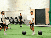 a group of men are playing soccer in a gym with a man wearing a shirt that says ' a ' on it