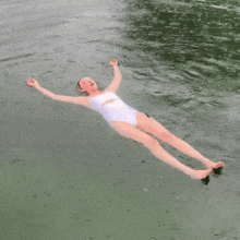 a woman in a white bathing suit is floating in the water