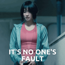 a woman in a red tank top is standing next to a wall with the words it 's no one 's fault above her