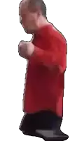 a man in a red shirt is dancing with his hands in his pockets