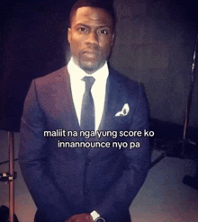 a man in a suit and tie is standing in front of a sign that says maliit na nga yung score ko inannounce nyo pa