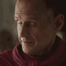 a close up of a man 's face wearing a red scarf