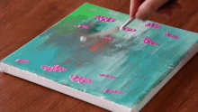 a person is painting a picture on a canvas with a brush