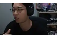 a man wearing glasses and headphones is sitting in front of a shelf