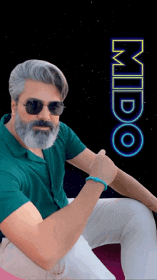a man with a beard and sunglasses is sitting in front of a sign that says mido