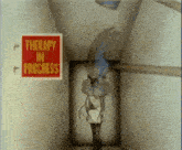 a red sign that says therapy in progress
